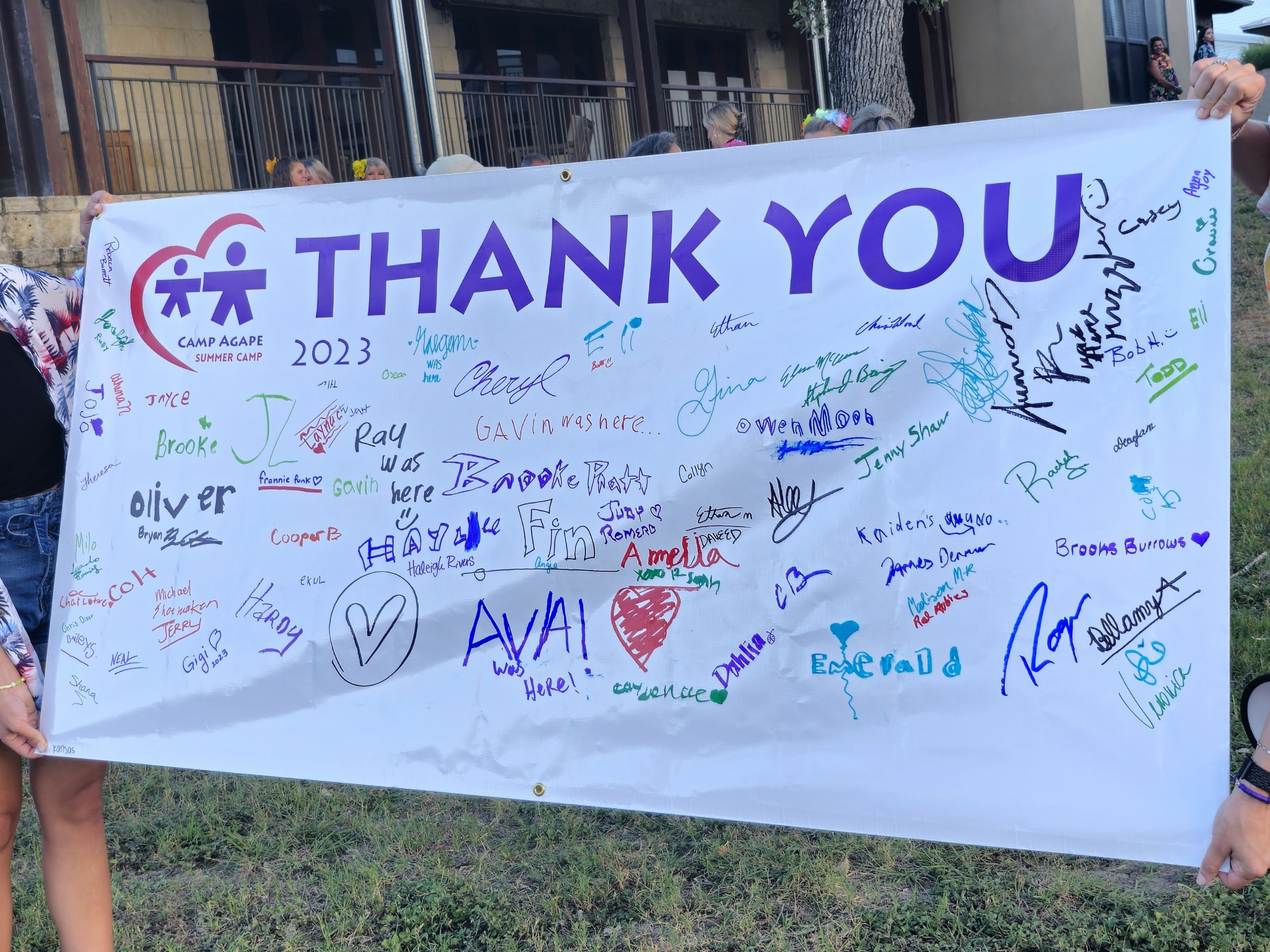 A large Camp Agape 2023 'Thank You' banner signed by campers, volunteers and families.