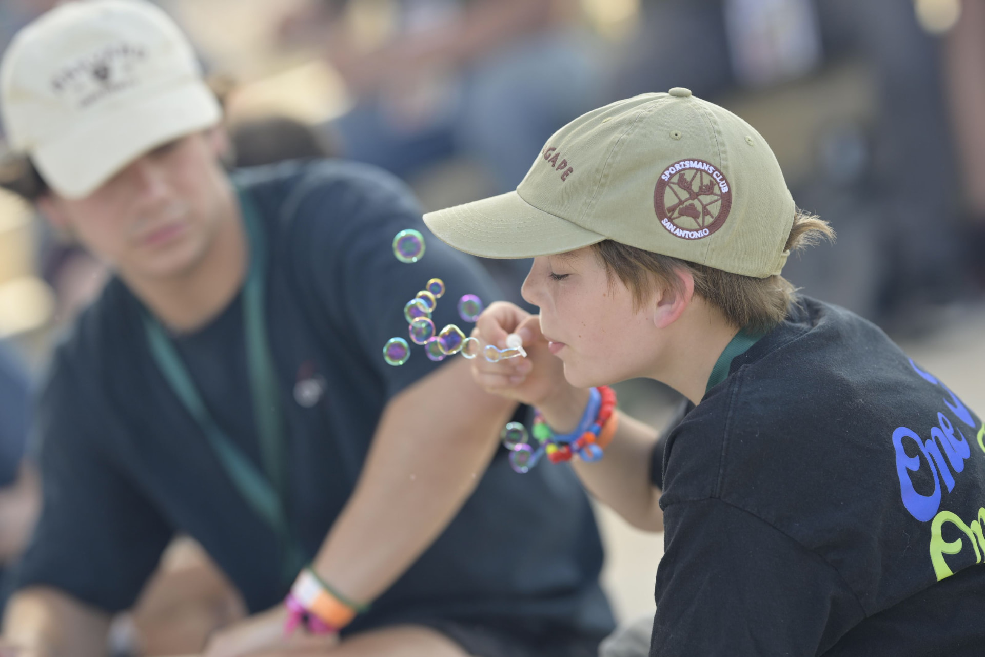 A camper blows bubbles beside his buddy during a quiet camp moment.